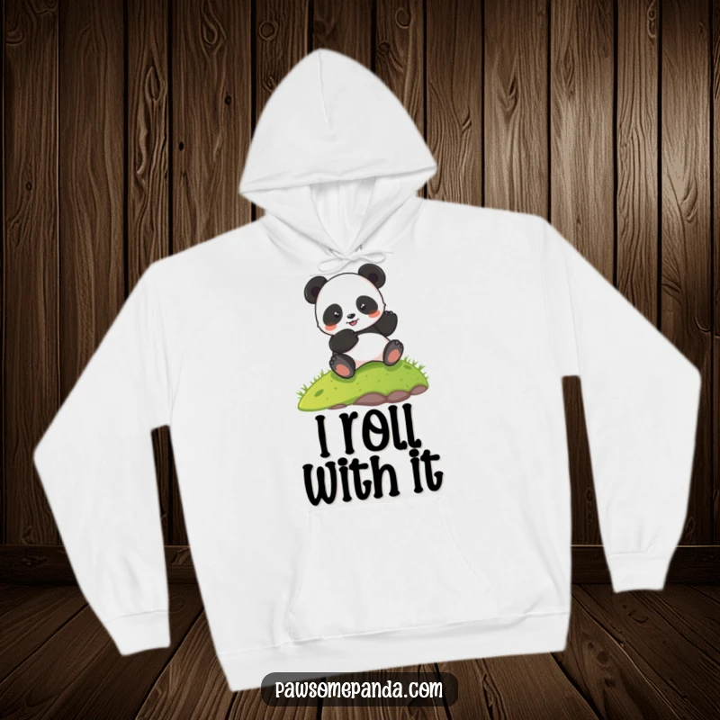 Funny hoodie depicting a cheerful panda character blissfully rolling down a lush green hill, radiating happiness and fun.