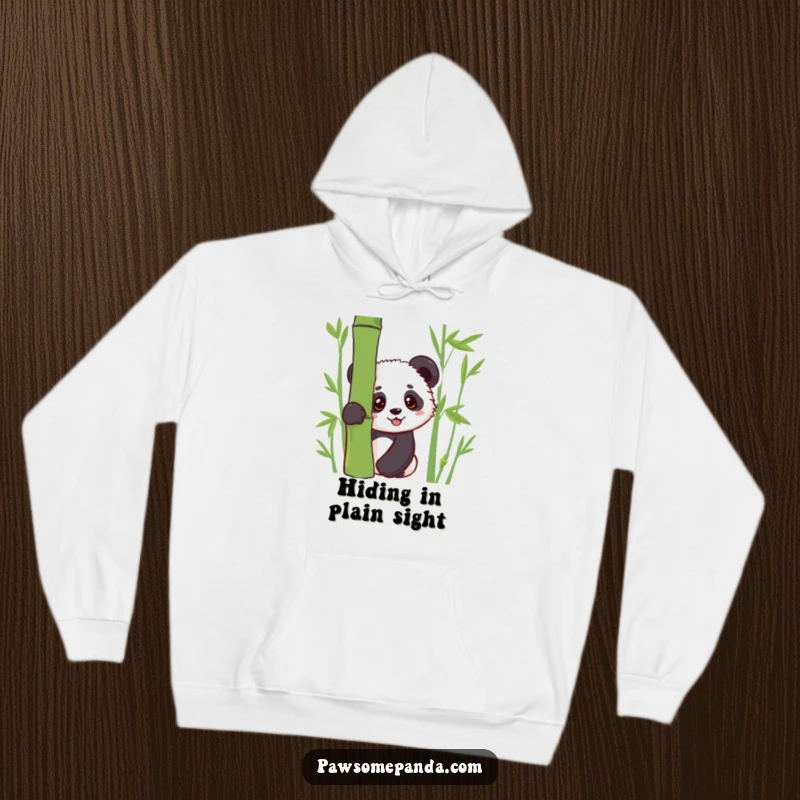Funny hoodie featuring a shy kawaii panda cub peeking from behind lush bamboo, offering warmth and a touch of playful mystery.