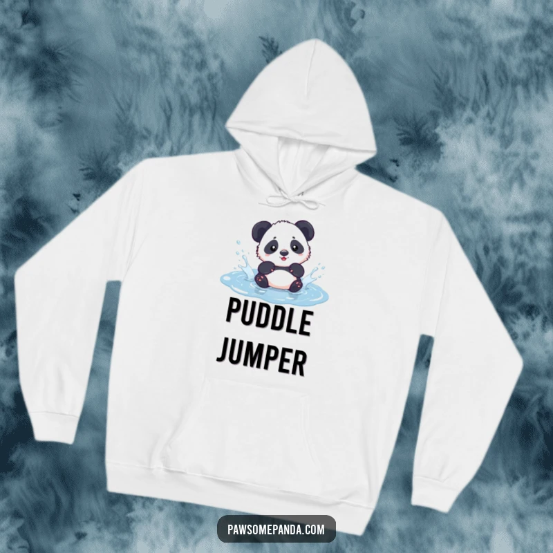Funny kawaii panda cub playfully splashing in a puddle, featured on a cozy hoodie, radiating warmth and joy.