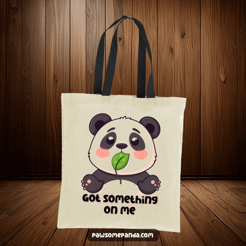 Funny tote bag depicting a panda with a leaf bizarrely stuck to its nose, looking surprised.